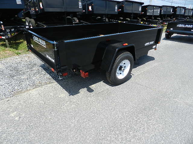 a black trailer is parked on the side of the road .