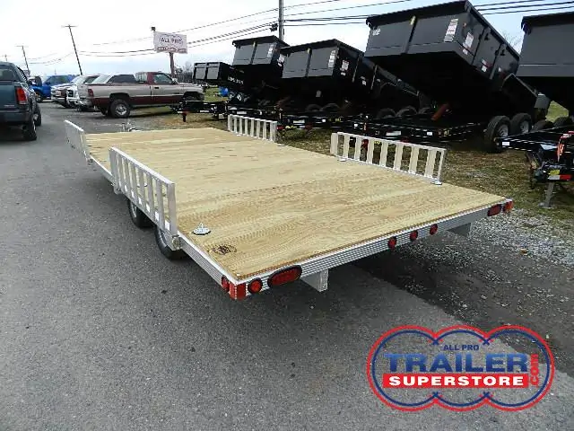 a trailer with a wooden deck is parked on the side of the road .