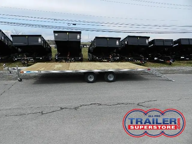 a Deckover trailer parked next to a row of dump trailers