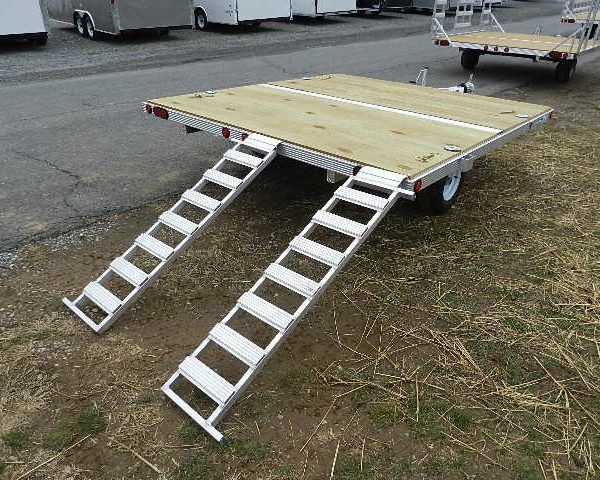 a trailer with a wooden deck and stairs attached to it