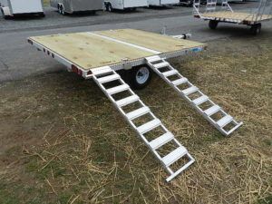 a trailer with stairs attached to it is parked in the grass