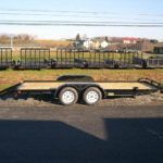 a flatbed trailer is parked on the side of the road .