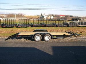 a flatbed trailer is parked on the side of the road .