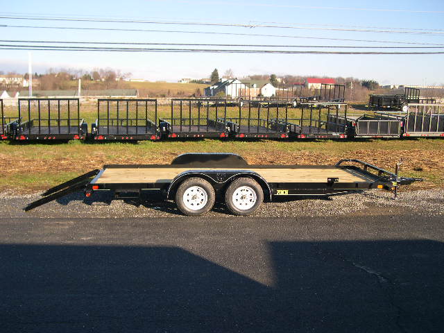a flatbed trailer is parked on the side of the road .