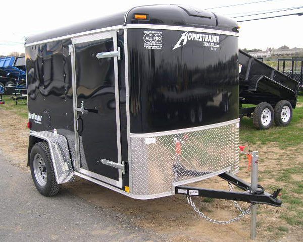 a black trailer is parked on the side of the road