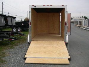 a trailer with a wooden floor is parked on the side of the road