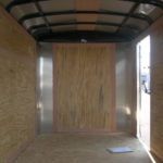 an empty trailer with wooden walls and a metal roof