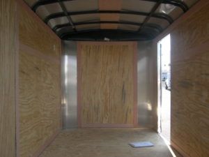 an empty trailer with wooden walls and a metal roof