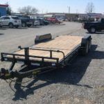 a trailer is parked on the side of the road in a parking lot .