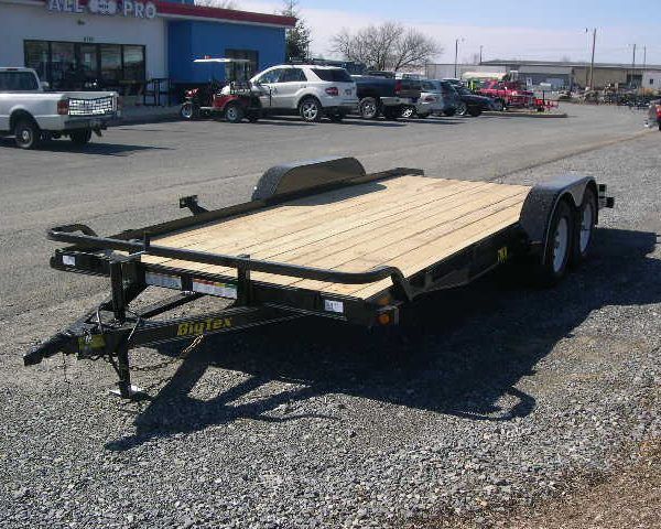 a Big Tex trailer parked in a gravel lot in front of a building