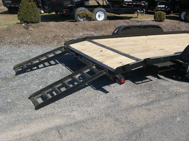 a black car trailer with slide in ramps attached to it