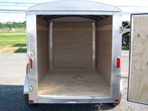the inside of an empty small cargo trailer with the door open