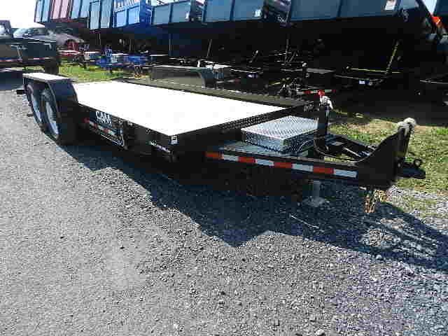 a CAM flatbed trailer is parked on the side of the road