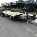 a wooden flatbed trailer is parked on the side of the road