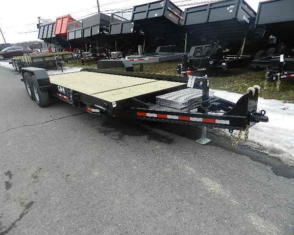 a wooden flatbed trailer is parked on the side of the road