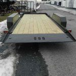a CAM Superline trailer with a wooden deck parked on the side of the road