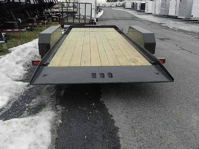 a CAM Superline trailer with a wooden deck parked on the side of the road
