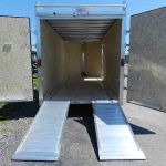 the back of a cargo trailer with ramps and the doors open .