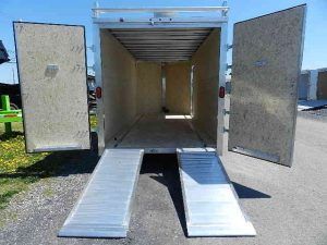the back of a cargo trailer with ramps and the doors open .