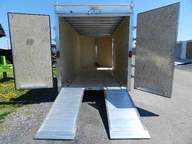 the back of a cargo trailer with ramps and the doors open .