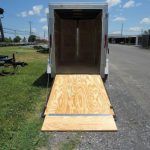 the back of a trailer with the door open and a wooden ramp .