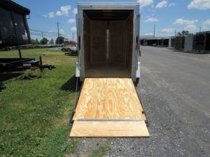 the back of a trailer with the door open and a wooden ramp .