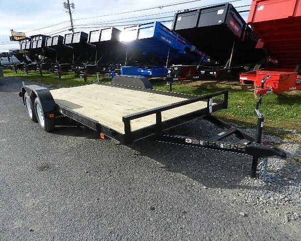 a trailer is parked on the side of the road next to a dumpster .