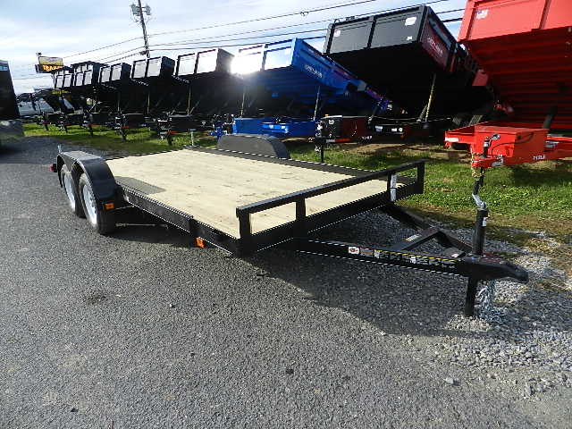 a trailer is parked on the side of the road next to a dumpster .