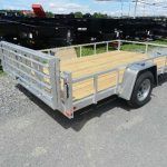 a trailer with a wooden deck parked on the side of the road