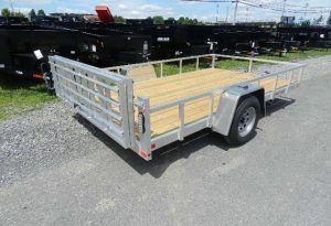 a trailer with a wooden deck parked on the side of the road