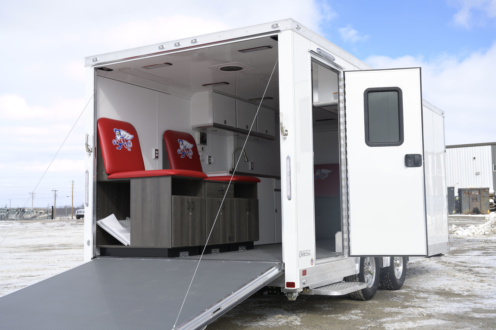 enclosed trailer with kitchen, seats, and cabinets inside