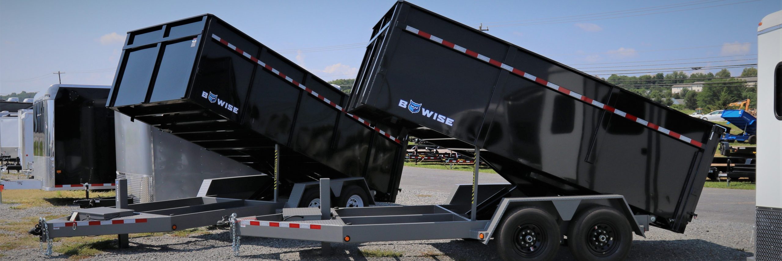 two black dump trailers with the word wise on them