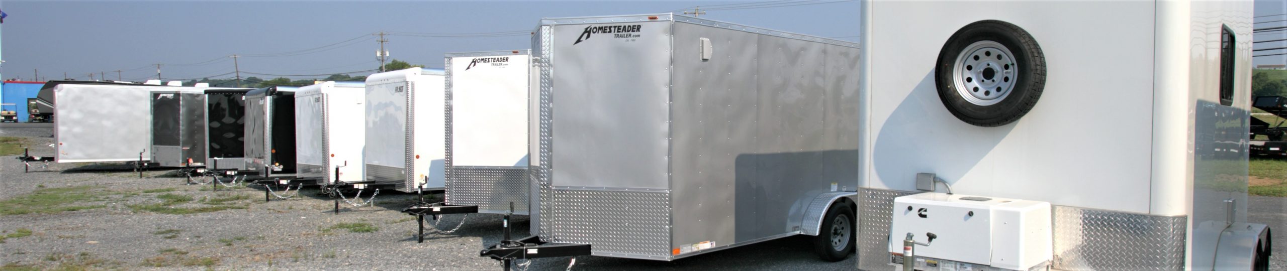 a row of multiple trailers lined up in a parking lot