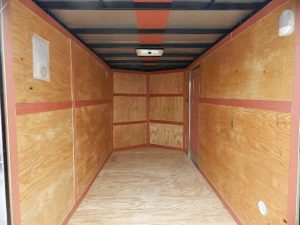 the inside of a Homesteader trailer with wooden walls and a wooden floor