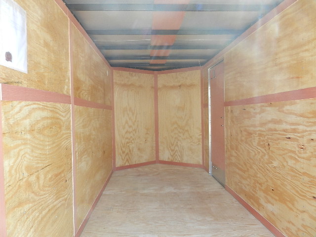 an empty trailer with wooden walls and a metal roof .