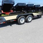 a flatbed trailer is parked on the side of the road .