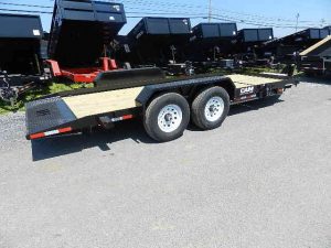 a flatbed trailer is parked on the side of the road .