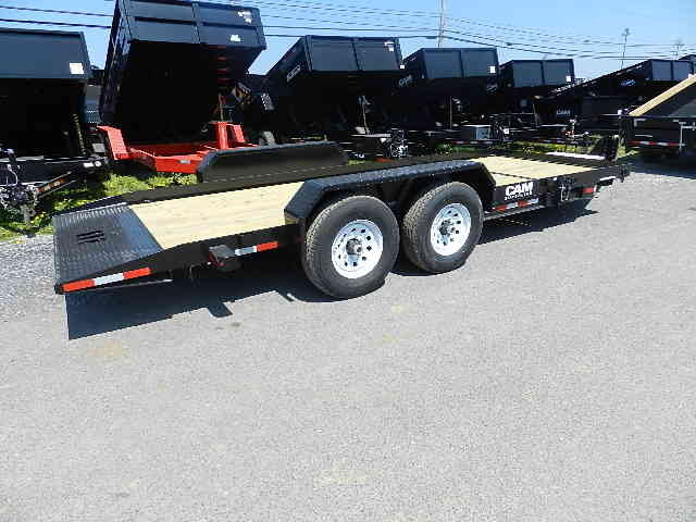 a flatbed trailer is parked on the side of the road .