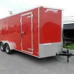 a red trailer is parked on the side of the road .