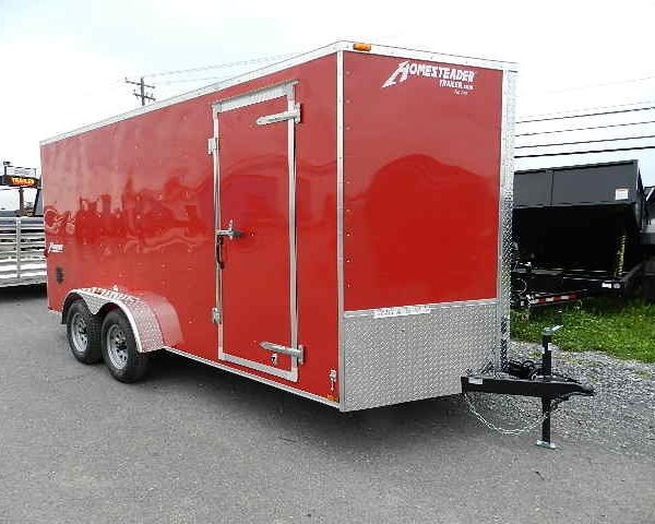 a red trailer is parked on the side of the road .