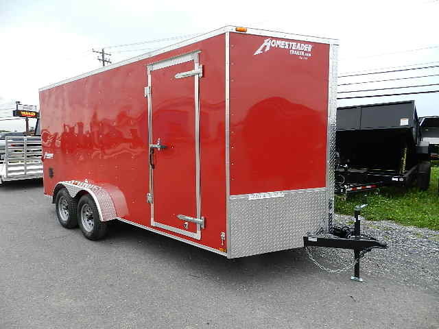 a red trailer is parked on the side of the road .