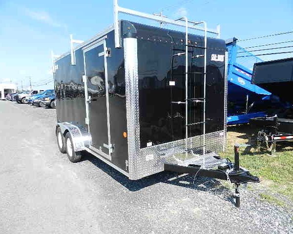 a black trailer with a ladder attached to it parked on the side of the road