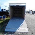 a trailer with the door open is parked on the side of the road .