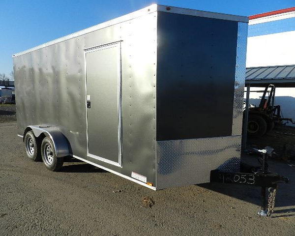 a black and silver trailer is parked in front of a building .