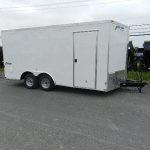 a white trailer is parked on the side of the road .