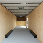 a long hallway with wooden walls and a gray floor .