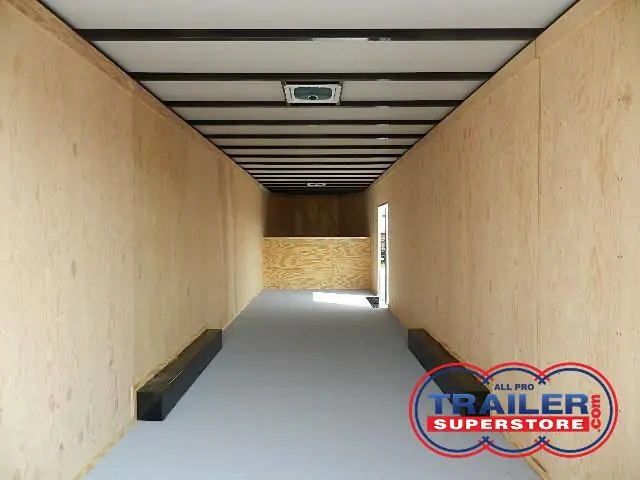 a long hallway with wooden walls and a gray floor .