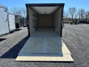 a trailer is sitting on top of a wooden platform in a gravel lot