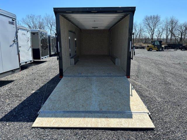 a trailer is sitting on top of a wooden platform in a gravel lot