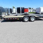 a Big Tex flatbed trailer is parked in a parking lot next to a row of trailers